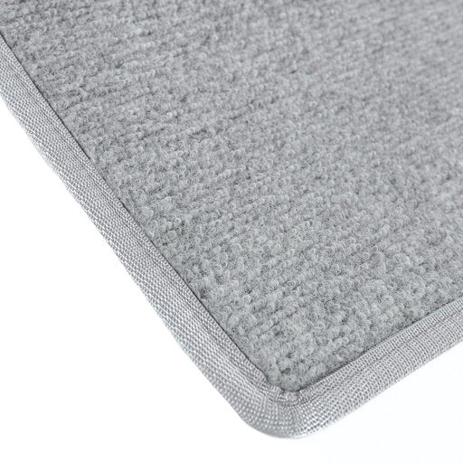 Vaaleanharmaa ovimatto kantatuilla reunoilla.