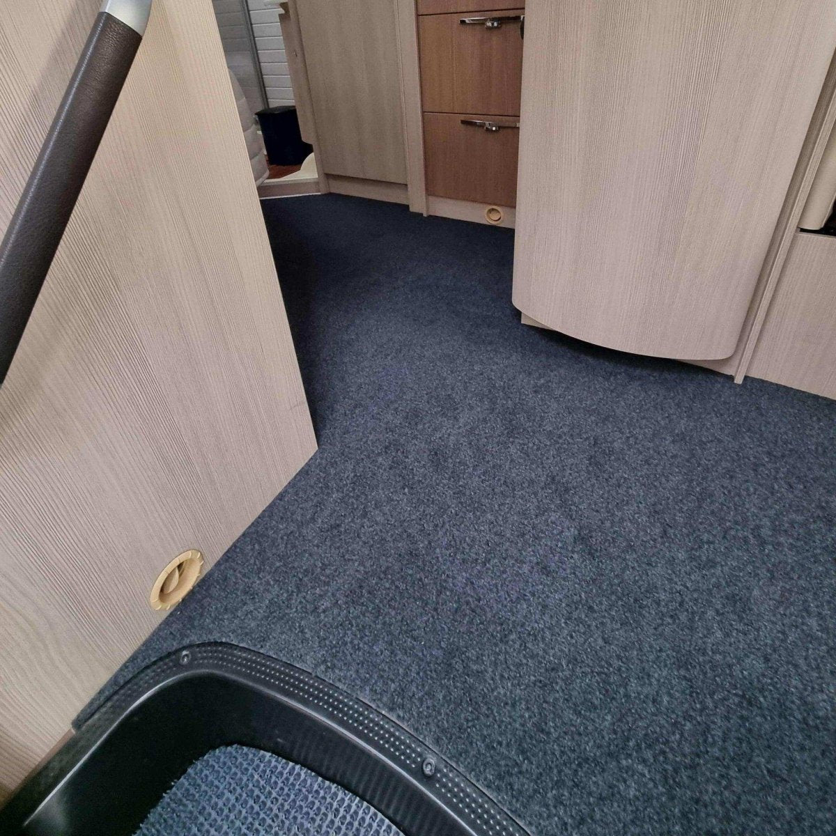 Keskiharmaa caravan-matto asennettuna asuntoautoon.