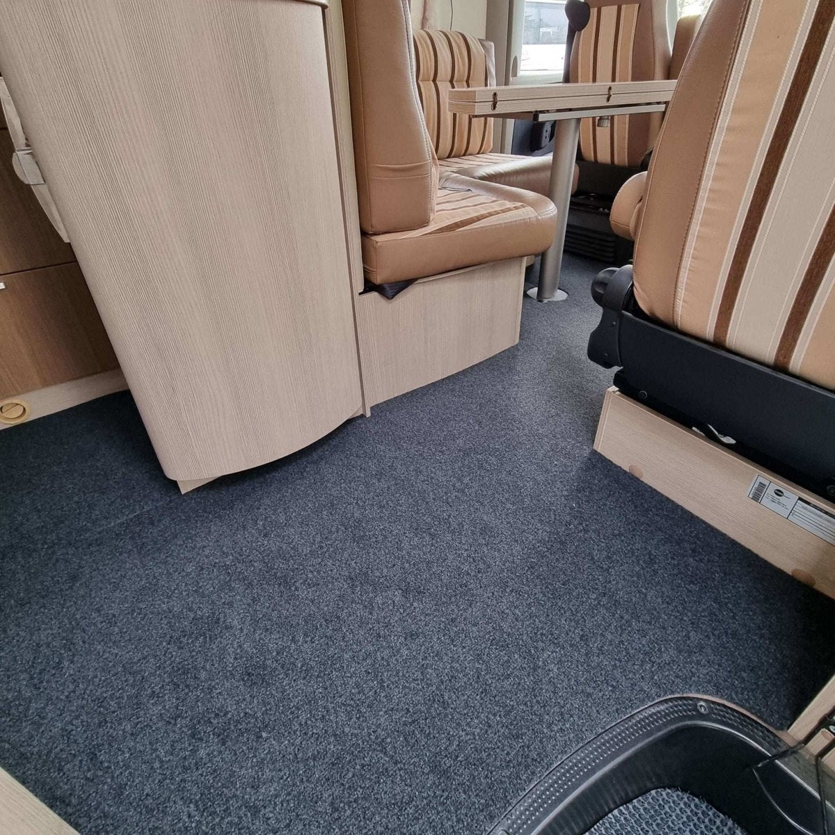 Keskiharmaa caravan-matto asennettuna asuntoautoon.