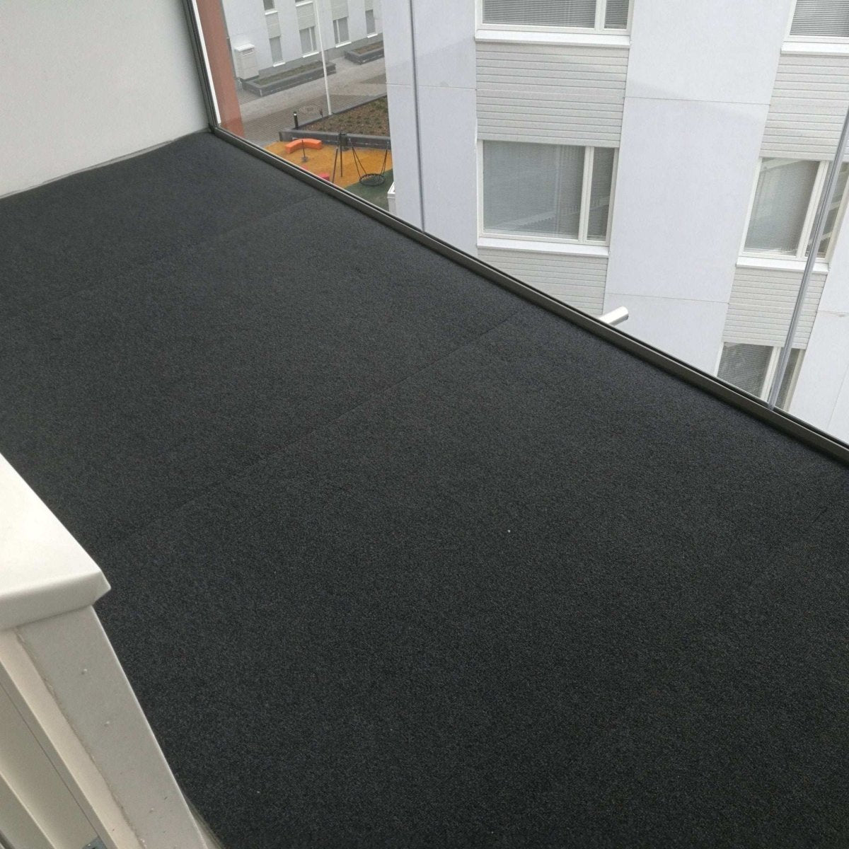 Tummanharmaa Dry Step parvekematto asennettuna.