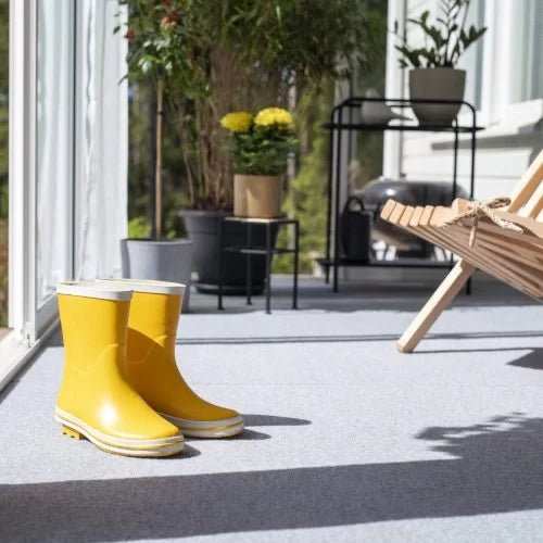 Vaaleanharmaa Dry Step terassimatto lasitetulla terassilla.